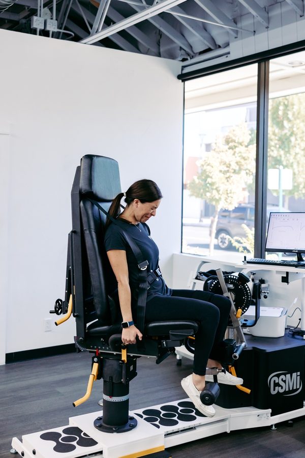 A woman completing a strength test on a testing machine at Nevada Physical Therapy